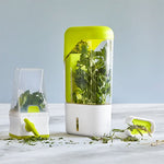 Herb Keeper with fresh herbs on a light surface.