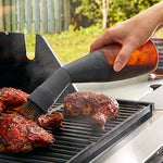 Person using flexible grill basting on food outdoors.