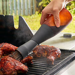 Person using flexible grill basting on food outdoors.