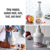 White kitchen food chopper being utilized to chop various ingredients on a kitchen countertop.
