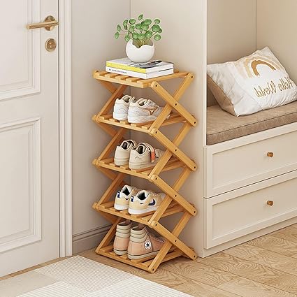 Wooden shoe rack with shoes on a wooden floor next to a door and sitting area.