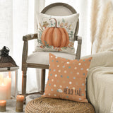 Decorative pillows with pumpkin and 'Hello Fall' design on a chair.