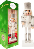 Wooden nutcracker figurine with silver hat and white outfit next to its packaging