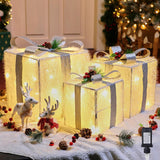 Decorative LED light boxes with reindeer and Christmas decorations on a snowy surface.