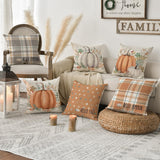 Living room with fall-themed decor including pillows, candles, and a lantern.