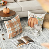 Decorative pillows with pumpkins and a magazine on a coffee table in a living room.