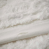 Close-up of textured white fabric with a soft, plush surface.