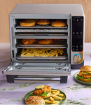 Deluxe Air Fryer and Toaster Oven with food items on a table.