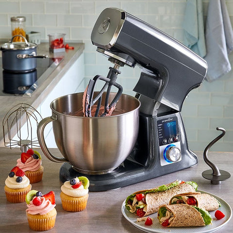 Deluxe Electric Stand Mixer on kitchen counter with food, including cupcakes.