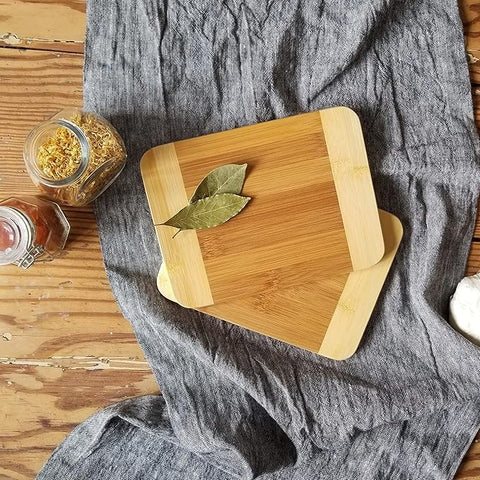 Set of wooden cutting boards on a gray cloth with herbs on top