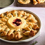 Baked brie with cranberry sauce surrounded by croissants on Large Round Pizza Stoneware Dish.