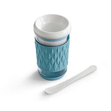 Light blue, frozen drink maker tumbler cup and matching spoon on a white background.