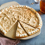 Dessert on a medium pizza stone on a blue surface.