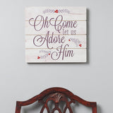 Decorative sign with text 'Oh Come Let Us Adore Him' on a white background, with a wooden chair at the bottom.