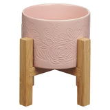 Pink ceramic planter pot and bamboo stand on a white background.