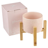 Pink ceramic planter pot with bamboo stand and matching pink gift box on a white background.
