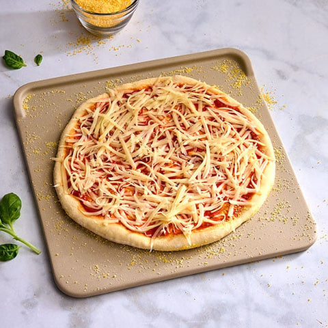Unbaked pizza with cheese on a baking tray on a marble surface