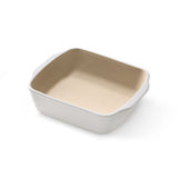 Square stoneware baking dish with beige interior and white exterior on a white background.