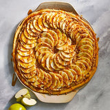 Apple tart with sliced apples on a stoneware dish.