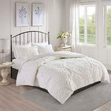 White comforter set on a bed in a bright bedroom with large windows.