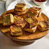 Baked goods on a wooden cake stand with a white background.