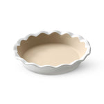White, stoneware pie baking dish with scalloped edge on a white background.