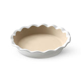 White, stoneware pie baking dish with scalloped edge on a white background.